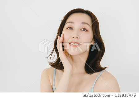 Young woman touching cheeks 112933479