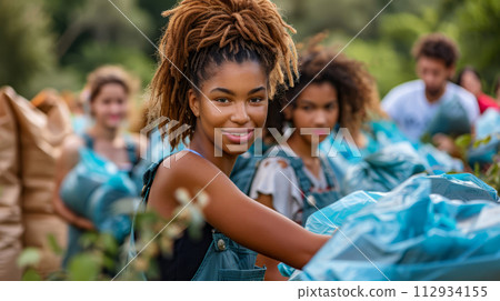 Youthful woman volunteers in community clean-up, promoting environmental care. 112934155