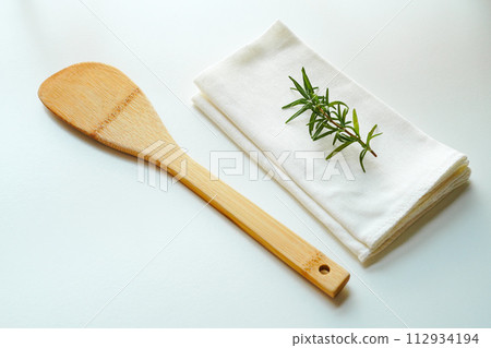 Wooden rice scoop and white dish towel on white background Wooden rice scoop and white dish towel on white background 112934194