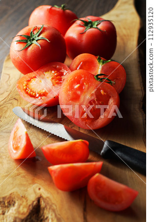 tomatoes cut on a cutting board 112935120