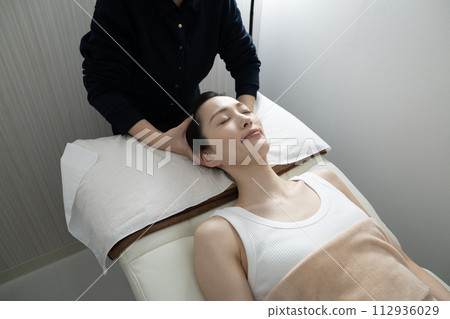 A woman receiving head spa treatment 112936029