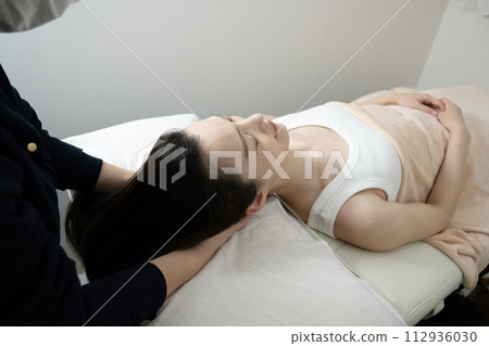 A woman receiving head spa treatment 112936030