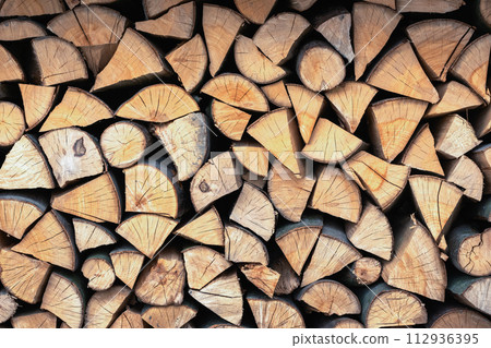 Split hardwood firewood stacked in a row 112936395
