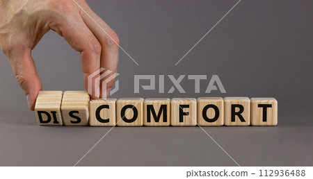 From discomfort to comfort symbol. Psychologist turns a cube and changes the word 'discomfort' to 'comfort'. Beautiful grey background, copy space. Business, discomfort or comfort concept. 112936488