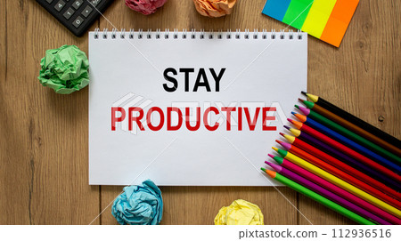 White note with inscription 'stay productive' on beautiful wooden table, colored paper, colored pencils, and calculator. Business concept. 112936516