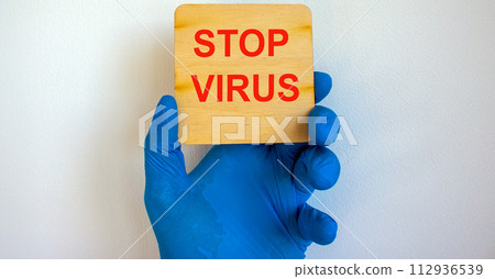 COVID-19 Pandemic Coronavirus concept.The doctor holds in his hand a tablet saying stop virus. Gloved hand. 112936539