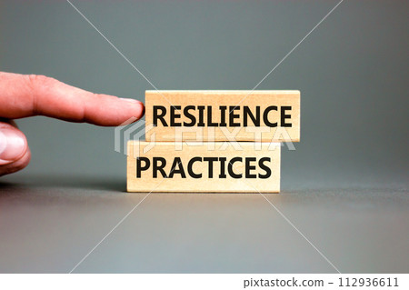 Resilience practices symbol. Concept word Resilience practices typed wooden blocks. Beautiful grey table grey background. Businessman hand. Business and resilience practices concept. Copy space. Resilience practices symbol. Concept word Resilience practices typed wooden blocks. Beautiful grey table grey background. Businessman hand. Business and resilience practices concept. Copy space. 112936611