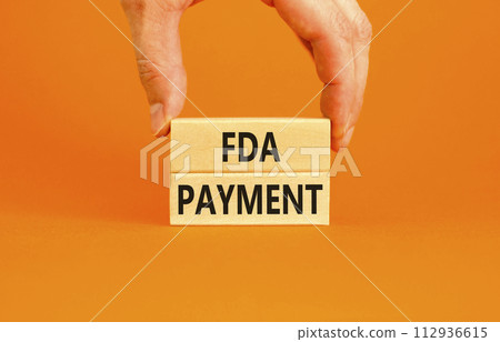 FDA Food and Drug Administration payment symbol. Concept words FDA payment on beautiful wooden blocks. Beautiful orange table background. Businessman hand. Business FDA payment concept. Copy space. FDA Food and Drug Administration payment symbol. Concept words FDA payment on beautiful wooden blocks. Beautiful orange table background. Businessman hand. Business FDA payment concept. Copy space. 112936615