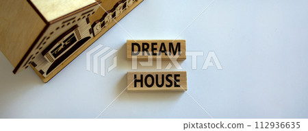 Wooden blocks form the words 'dream house' near miniature house. Beautiful white background. Business concept. 112936635
