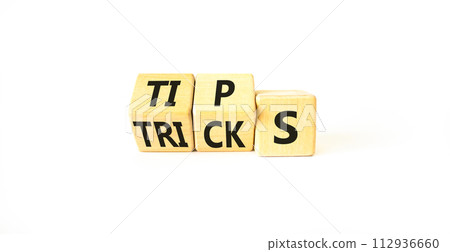 Tips and tricks symbol. Turned wooden cubes and changed the word tricks to tips. Beautiful white table, white background. Business, tips and tricks concept. Copy space. Tips and tricks symbol. Turned wooden cubes and changed the word tricks to tips. Beautiful white table, white background. Business, tips and tricks concept. Copy space. 112936660