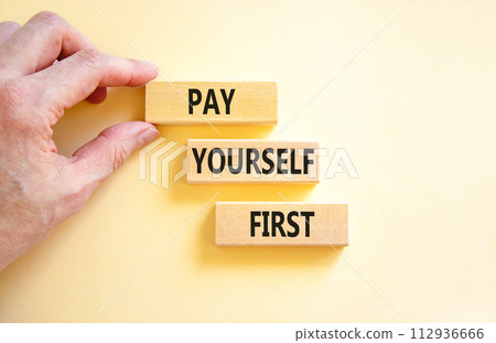 Pay yourself first symbol. Concept words Pay yourself first on beautiful wooden blocks. Beautiful white table white background. Businessman hand. Business and pay yourself first concept. Copy space. Pay yourself first symbol. Concept words Pay yourself first on beautiful wooden blocks. Beautiful white table white background. Businessman hand. Business and pay yourself first concept. Copy space. 112936666
