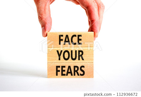 Face your fears and support symbol. Concept words Face your fears on wooden blocks. Businessman hand. Beautiful white table white background. Business and Face your fears quote concept. Copy space. 112936672