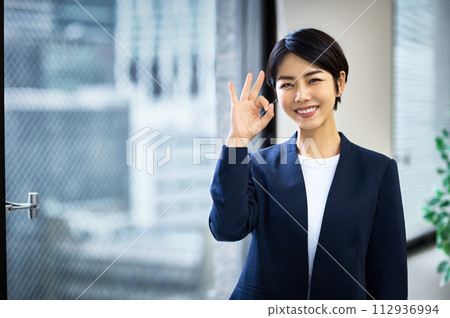 在辦公室工作的穿著西裝的微笑女商人 112936994