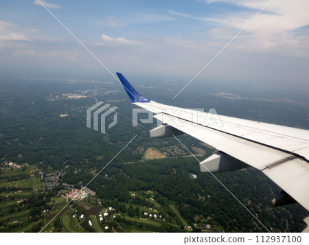 airplane wing as it flies into city airplane wing as it flies into city 112937100