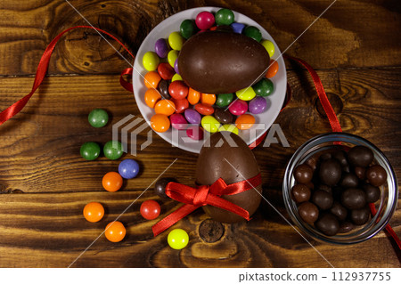 Easter composition with chocolate eggs on wooden background Easter composition with chocolate eggs on wooden background 112937755