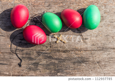 Painted Easter eggs and Christianity golden cross on rustic wooden background 112937785