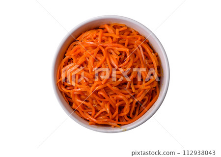 Tasty spicy Korean carrot with spices and herbs on a dark concrete background 112938043