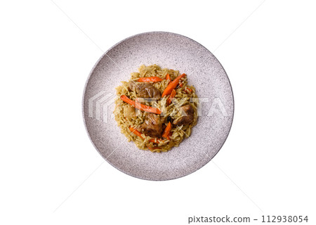 Delicious pilaf with vegetables, salt, spices and herbs in a ceramic plate 112938054