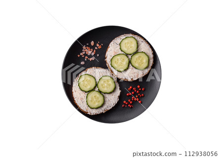 Delicious vegetarian sandwich with grilled toast, cream cheese, cucumbers and seeds 112938056