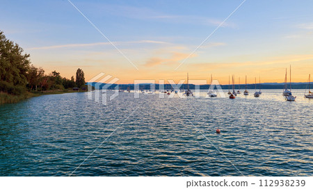 Bodensee Lake Sunrise Panorama. Morning Sunlight Over Tranquil Waters. Bodensee Lake Sunrise Panorama. Morning Sunlight Over Tranquil Waters. 112938239