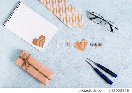 Father's day gift, notebook, tie, glasses, screwdrivers and inscription on blue background 112938896