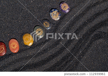 Healing crystals on black sand background Healing crystals on black sand background 112939961