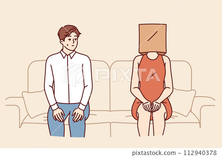 Indecisive man sits near woman with paper bag on head and is afraid of becoming acquainted 112940378