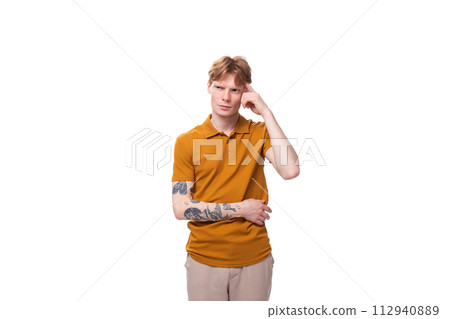 young inspired genius caucasian male student with red hair dressed in yellow t-shirt 112940889