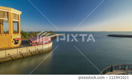 Boats passing to harbor at the Sharq Marina morning timelapse after sunrise in Kuwait. Kuwait City, Middle East 112941021