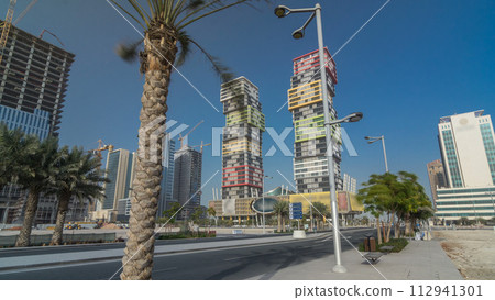 Doha skyline timelapse hyperlapse with colorful Al Marina Twin Towers building located the Lusail area of the capital of Qatar. 112941301