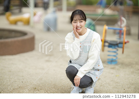 Nursery teacher watching over children in the park 112943278