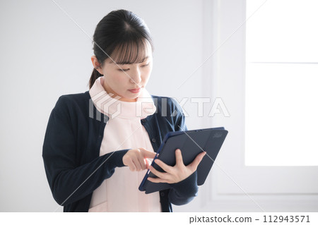 Nurse operating a tablet 112943571