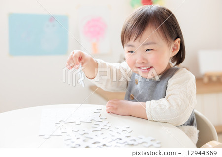Infants and toddlers playing with jigsaw puzzles 112944369