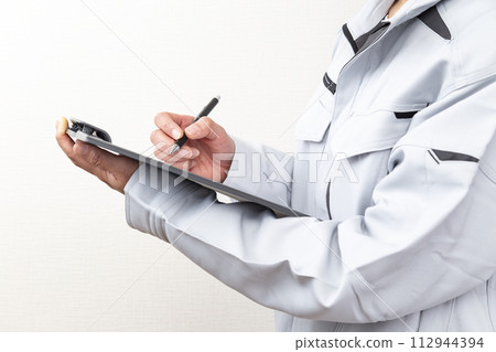 Hand of a woman holding a clipboard Hand of a woman holding a clipboard 112944394