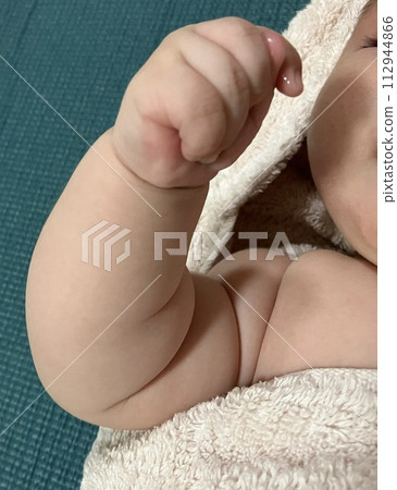 Baby staring at his own finger and sucking his thumb 112944866