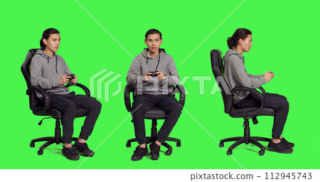 Young gamer playing videogames over full body greenscreen template, using joystick and enjoying competition with people online. Person having fun with rpg action contest on console. 112945743