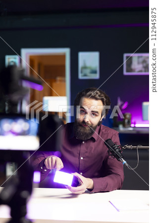 Tech specialist in studio filming technology review of mini led lights using professional camera. Video editor showing filming equipment to subscribers, recording with specialized devices 112945875