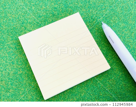Yellow sticky note and white pen (green background) 112945984