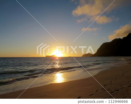 Early Morning Sunrise on Waimanalo Beach over Rabbit Island bursting over the island 112946666