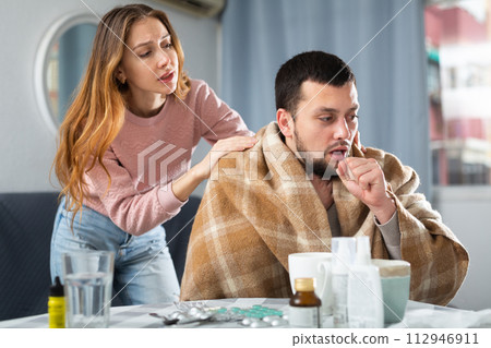 Sick man sitting with wife at home 112946911