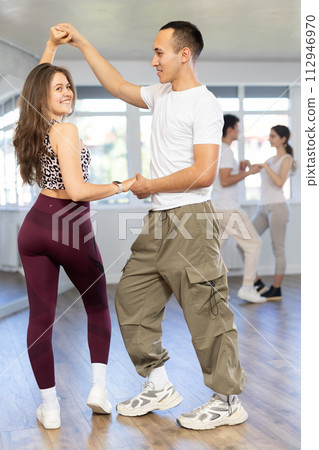 Young couple enjoying impassioned merengue in latin dance class Young couple enjoying impassioned merengue in latin dance class 112946970