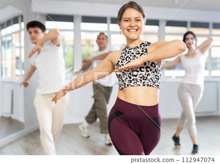 People in casual clothes studying modern dance element in classroom 112947074
