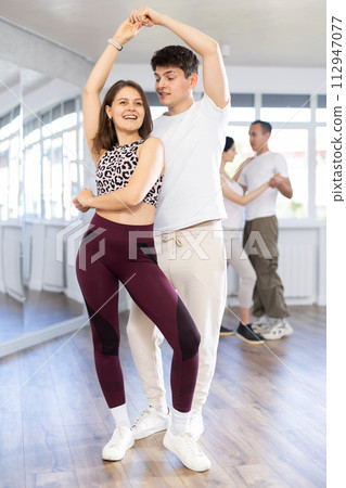 Young couple practicing passionate samba in dance class Young couple practicing passionate samba in dance class 112947077
