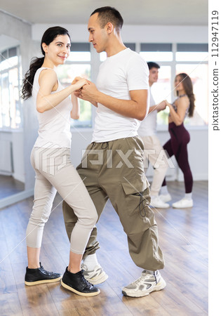 Couples of young men and women dancing waltz 112947119