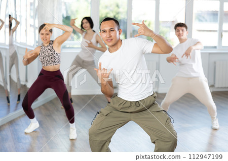 Guy enjoys active dancing, learns new movements, moves synchronously with participants of lesson Guy enjoys active dancing, learns new movements, moves synchronously with participants of lesson 112947199