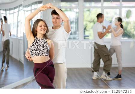 Smiling modern young couplel enjoying latin dance class 112947255