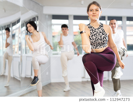 Girl with team of young like-minded people learn to dance modern dances Girl with team of young like-minded people learn to dance modern dances 112947273