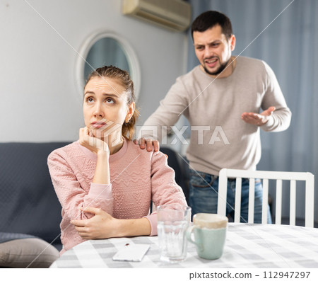 Offended woman sitting at home after spat with boyfriend Offended woman sitting at home after spat with boyfriend 112947297