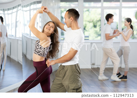 Young couple enjoying impassioned merengue in latin dance class 112947313