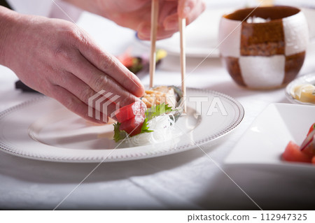 French chef, close-up of hands serving food, man preparing food French chef, close-up of hands serving food, man preparing food 112947325
